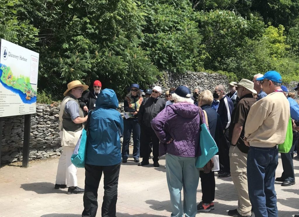 A costumed interpreter with a group of visitors in the courtyard