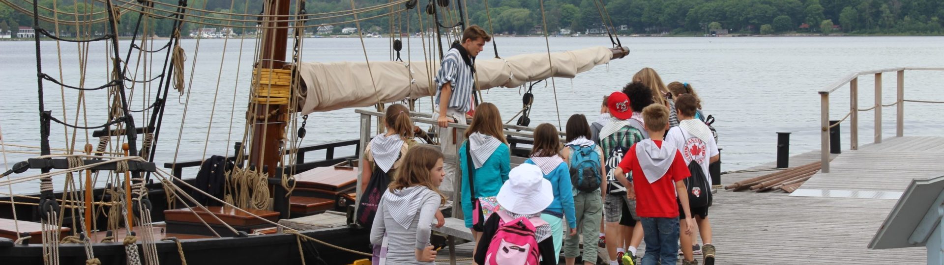 Interpreter with young students walking towards a ship.