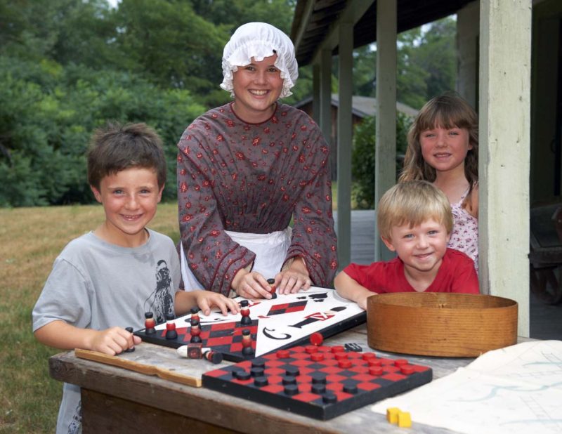 An interpreter playing checkers with some children.