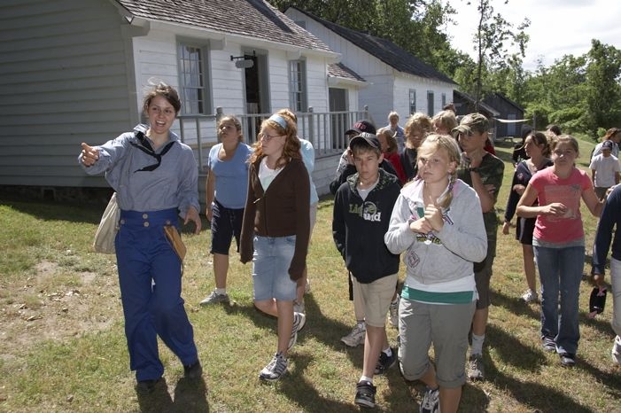 Children walking through Discovery Harbour with an interpreter