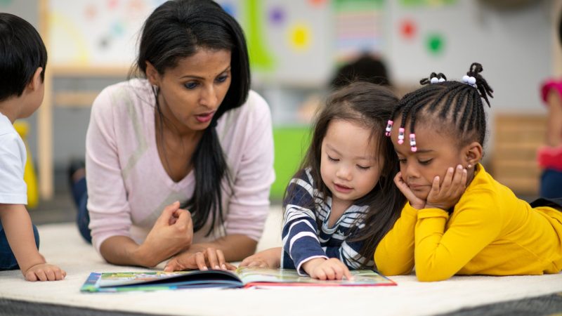 Une enseignante avec deux petits enfants dans une salle de classe