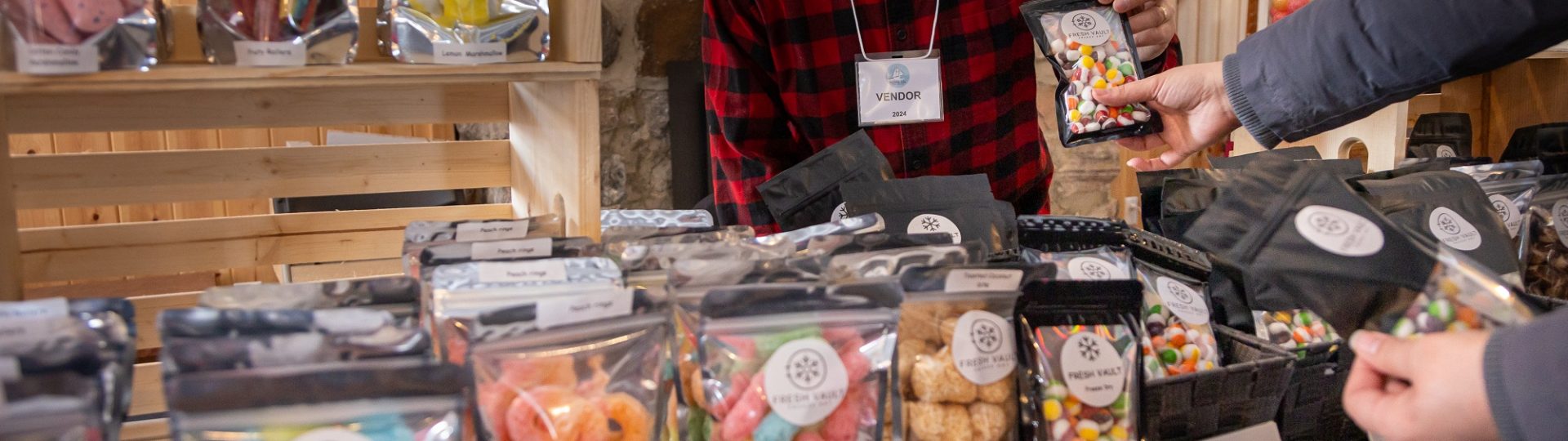 A vendor selling freeze dried candies at a discovery harbour market