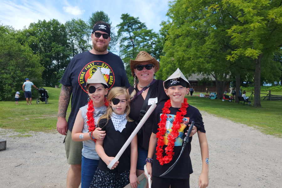 family standing in pirate costumes 