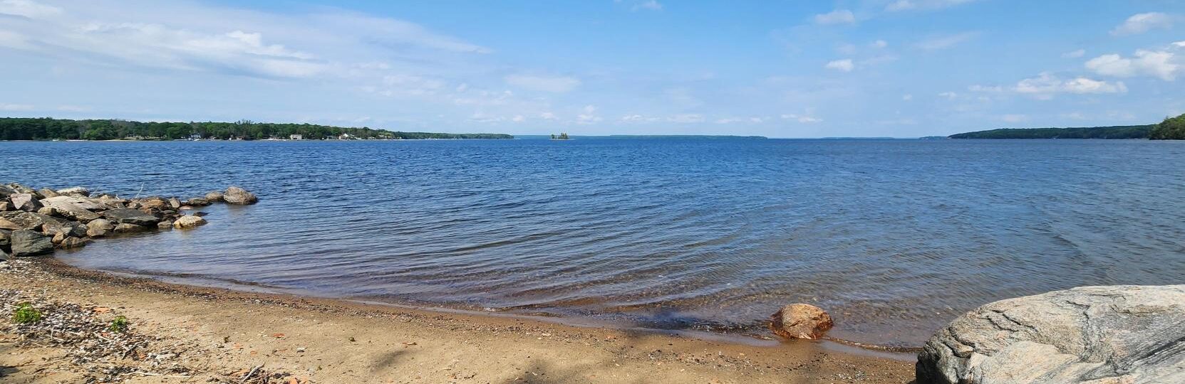 The original hull of the Techumseth ship sitting on a bed of sand in the Discovery Harbour museum