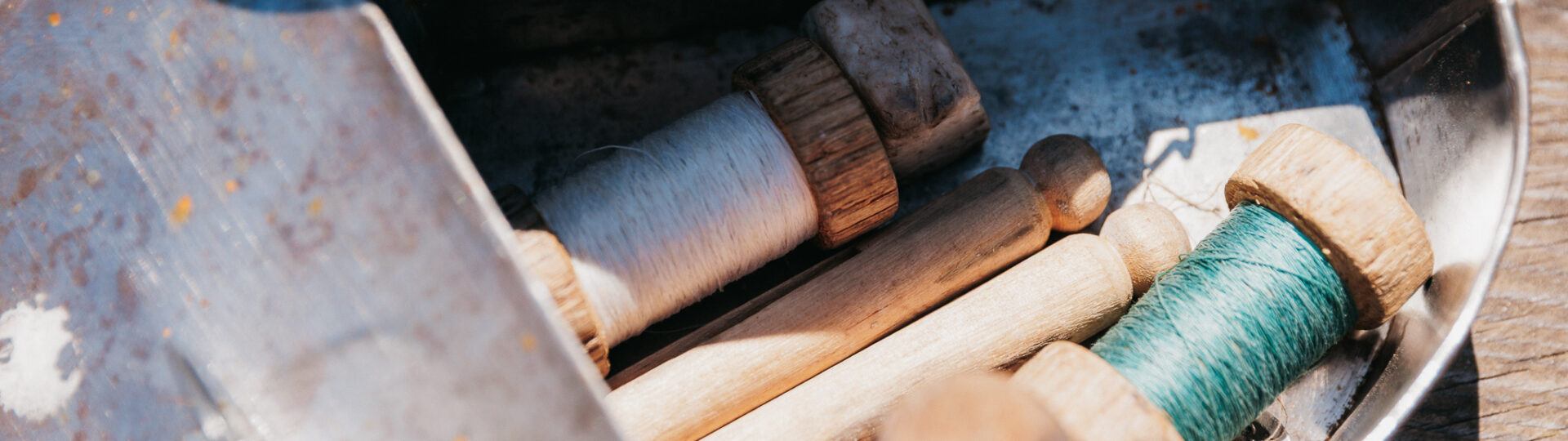 Blacksmith interpreter showing two young children the metal nail he forged in the blacksmith shop