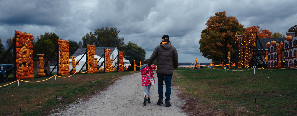 father and child take in the magical pumpkin displays at Pumpkinferno Discovery Harbour