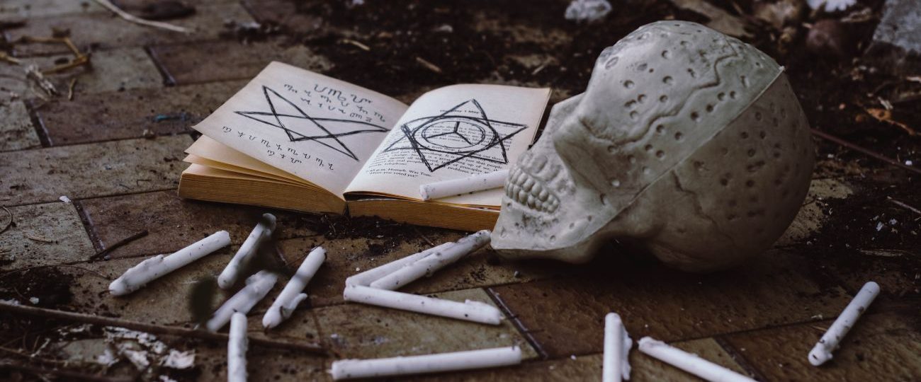 A book with a skull and cigarette sticks on the ground